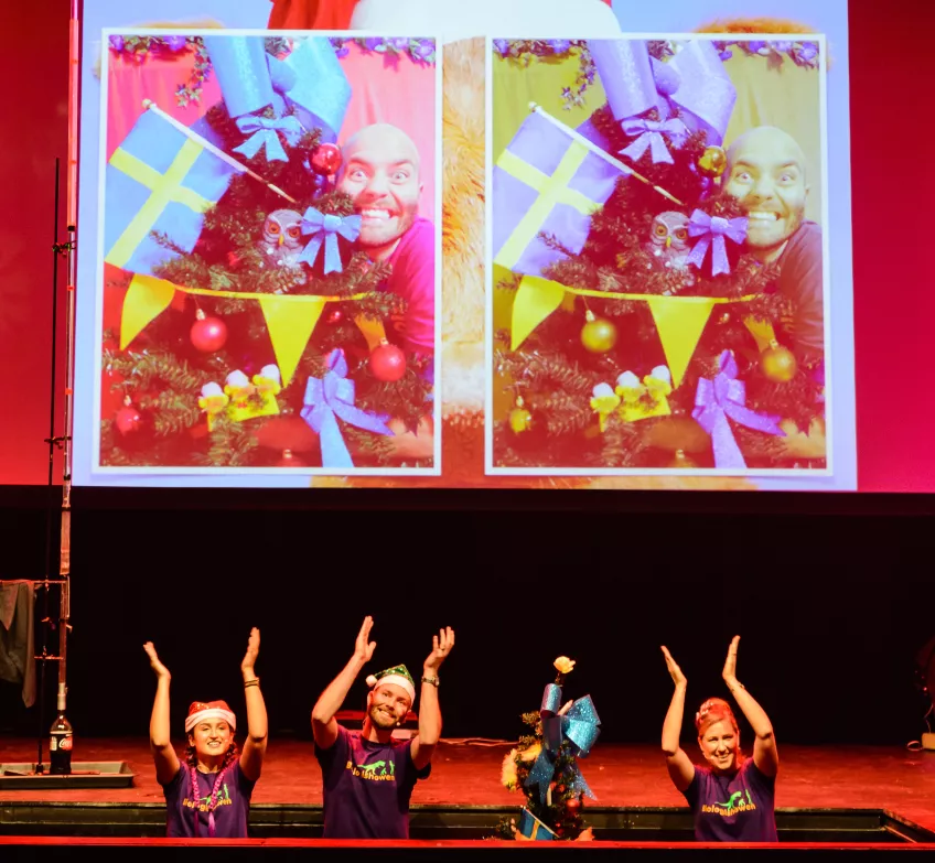 Four people are leaving the stage through a trap door. Photo.